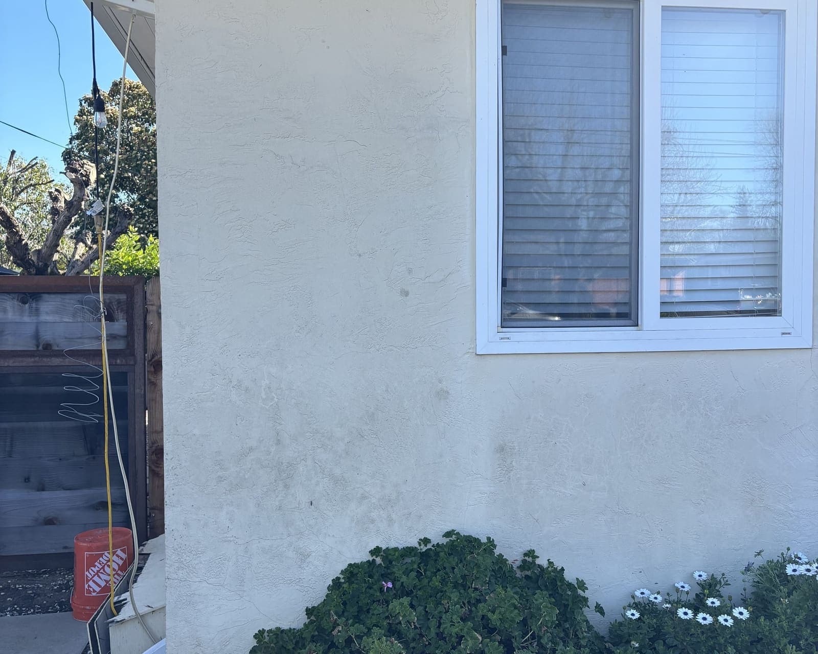 Dingy stucco exterior wall with dirt and stains before house washing